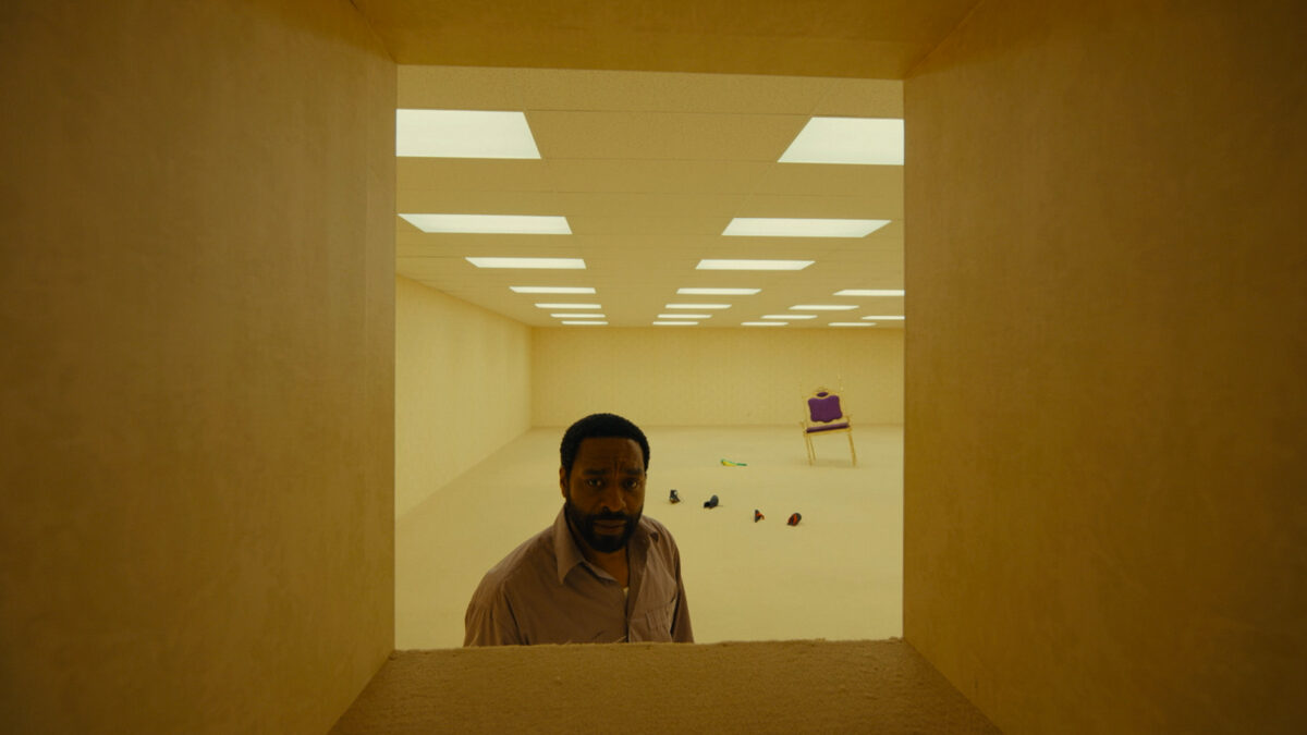 chiwetel Ejiofor staring through a hole in The Backrooms by Kane Parsons